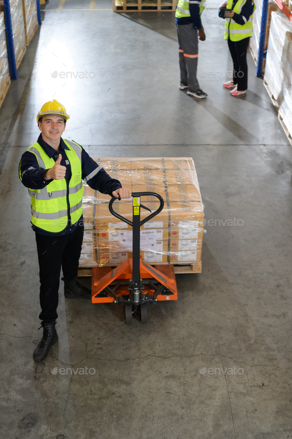 Worker in auto parts warehouse use a handcart to work to bring the box of auto parts