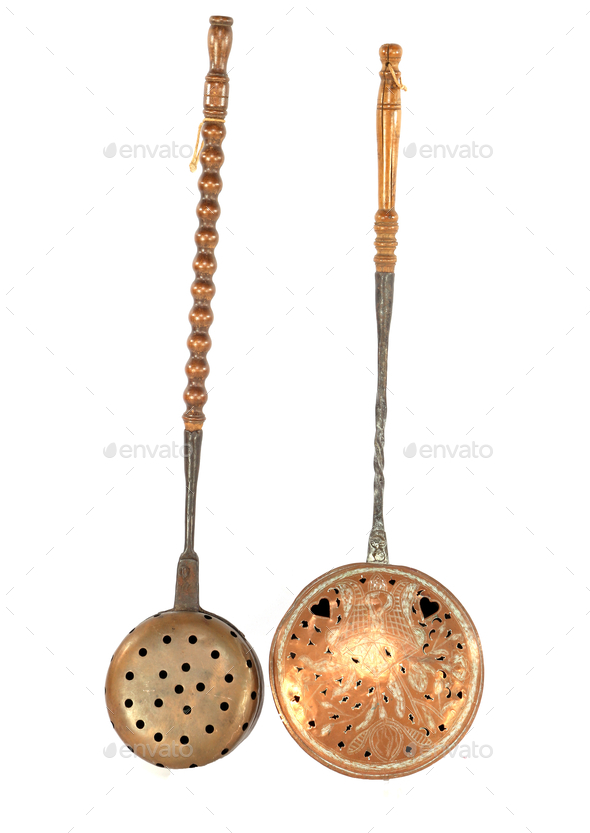 Vertical shot of copper slotted spoons with holes isolated on white