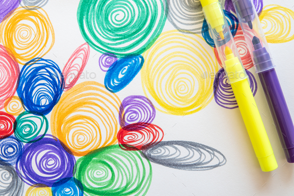 Closeup shot of colorful spiral drawings with yellow and purple markers