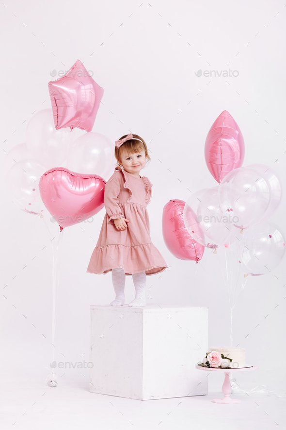 happy birthday 2 years old little girl in pink dress. white cake with ...