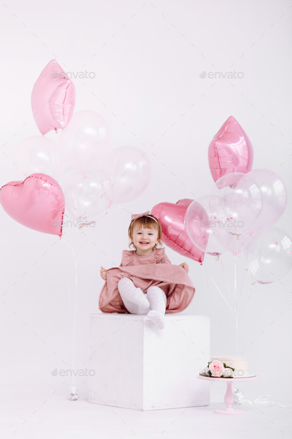 happy birthday 2 years old little girl in pink dress. white cake with ...