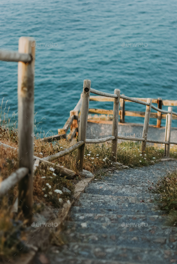 Stairs and wooden railing that goes down to the sea, natural walk
