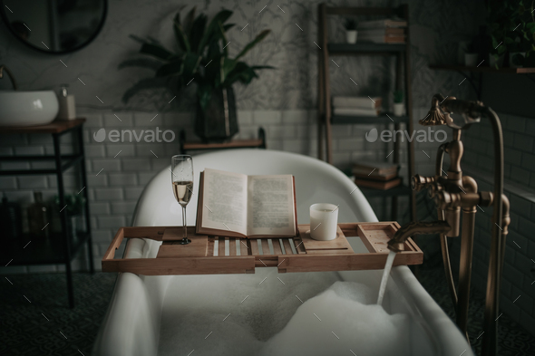 Luxury interior of eco style modern bathroom with oval bathtub and book on bamboo wood tray - Stock Photo - Images