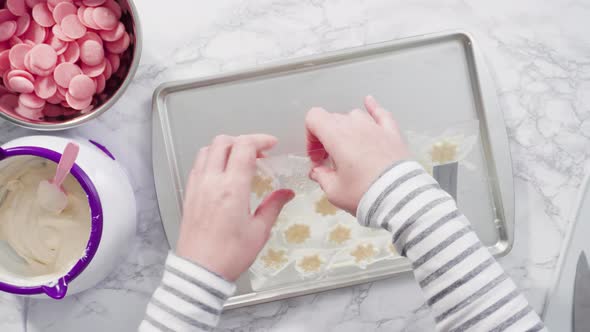 Flat lay. Step by step. Pouring melted chocolate into a plastic chocolate mold in the shape of snowf alt