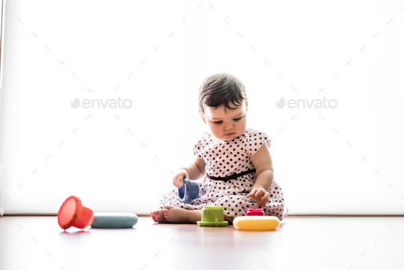 Eight months old toddler girl playing with colorful objects. Stock ...