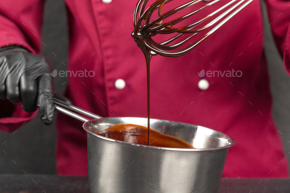Frozen motion. Handmade dessert. Pastry chef testing melting chocolate with a whisk. Hot chocolate - Stock Photo - Images