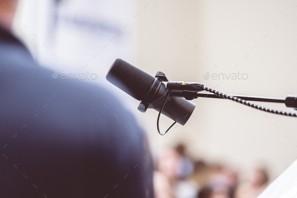 Man talking on the microphone on stage - public speech