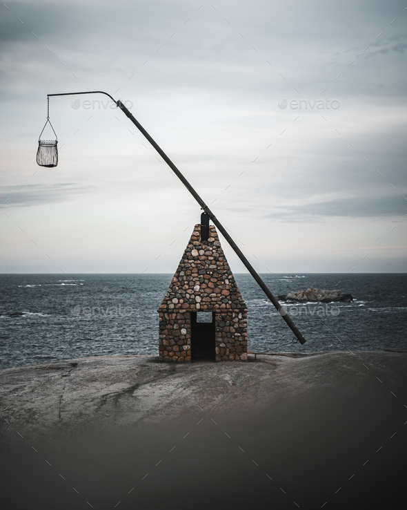 Vertical shot of an old stone lighthouse at Verdens Ende, Norway on a gloomy day