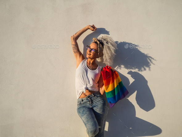 Curly-haired Spanish cute woman with a pride flag tote bag and