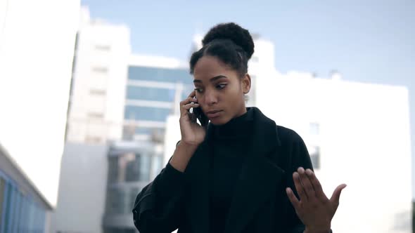 Low Angle Footage of Black Woman Talking on Mobile Phone Solving Business Issues Distantly alt