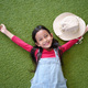 Top view of  6 years old asian girl is relax lying down on green grass and smiling with happy moment - PhotoDune Item for Sale