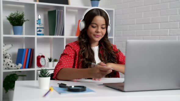 Happy Kid Waving Hello at Online School Lesson in Earphones Knowledge