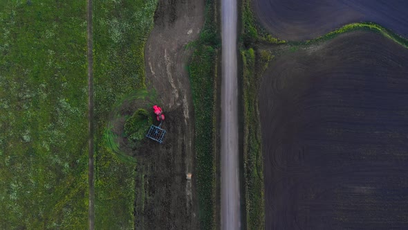 Red Tractor with  Plow in The Field alt