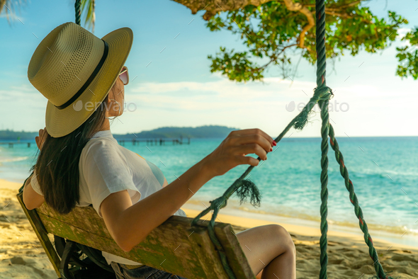 Young Asian Woman Sit And Relax On Swings At Seaside On Summer Vacation