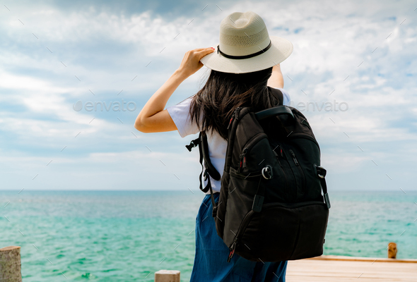 Happy young Asian woman in casual style fashion with straw hat and backpack. Relax and enjoy holiday - Stock Photo - Images
