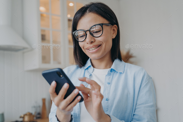 Happy female hold phone chat in social network read good news, shopping via  online store app at home Stock Photo by StudioVK