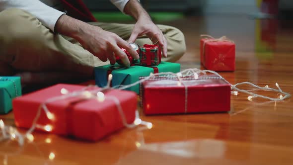 Close up attractive Asian man making a gift box in the living room at home.