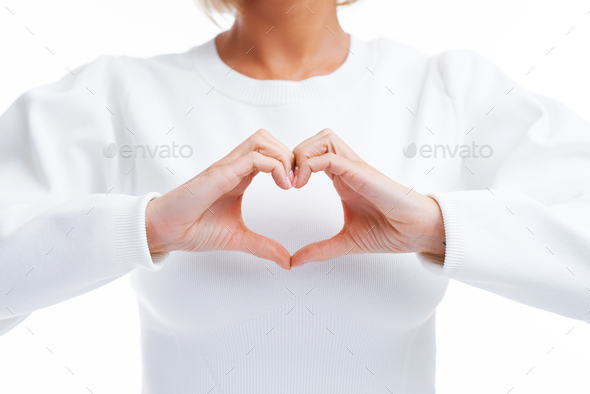 Picture of blonde woman isolated over white background showing heart - Stock Photo - Images