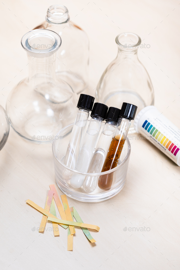 test tubes with liquids, flask and indicator paper