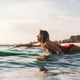 side view of young woman in swimming suit surfing alone in ocean Stock  Photo by LightFieldStudios