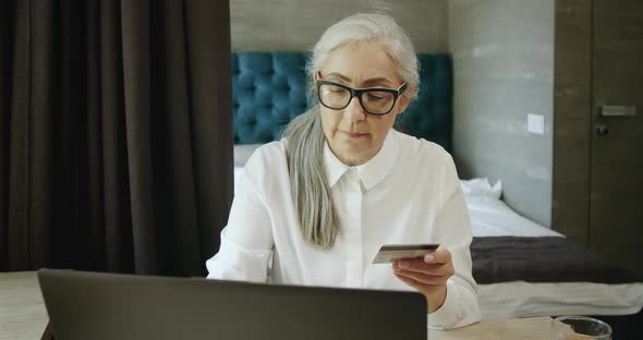 Retiree Entering Credit Card Number on Laptop