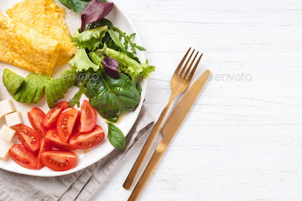 French omelet, avocado, tomatoes, avocado, and cheese on plate. - Stock Photo - Images