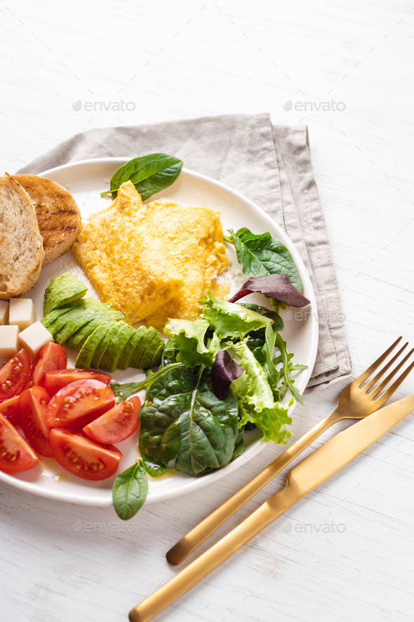 French omelet, avocado, tomatoes, avocado, and cheese on plate. - Stock Photo - Images