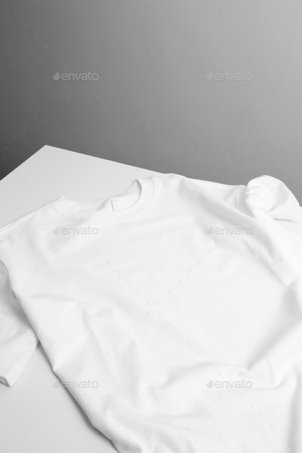 Basic white t-shirt on table. Mock up for branding t-shirt. Copy space