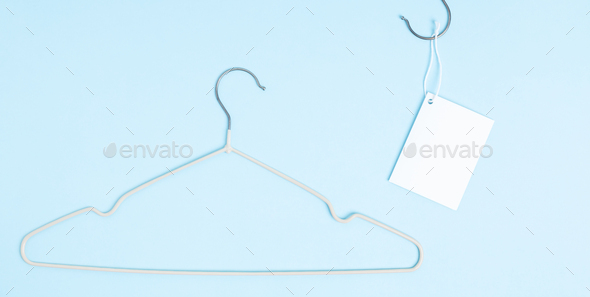 Creative flat lay hanger with white paper label. Clothing tag, label blank mockup template