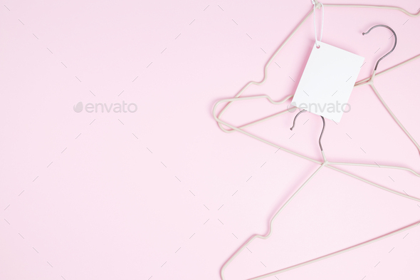 Creative flat lay hangers with white paper label. Clothing tag, label blank mockup template