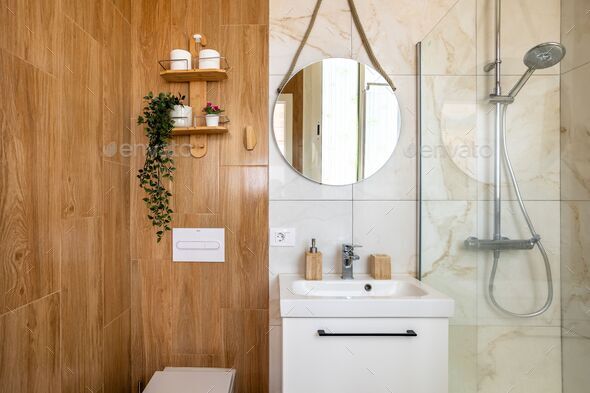 Fancy bathroom with ceramic wall, circular mirror, shower head and white sink