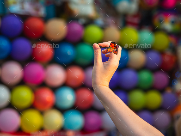 Person playing pop balloons with darts game