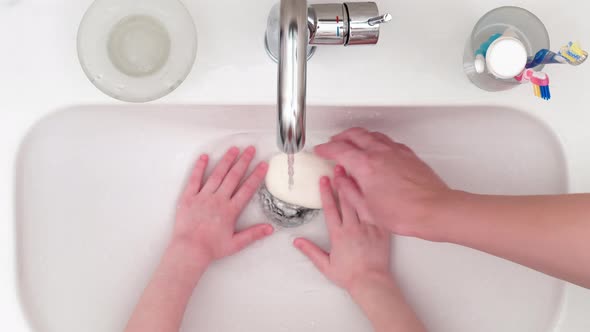 4K - Hands hygiene. Woman teaches her child to wash hands alt