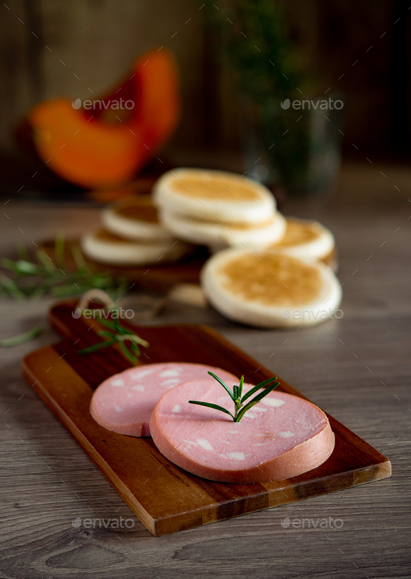 slices of Bologna PGI mortadella on wooden cutting board - Stock Photo - Images