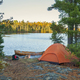 Campsite with orange tent and canoe on northern Minnesota lake at sunrise during autumn - PhotoDune Item for Sale