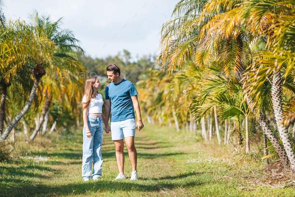Family of daughter and father having fun among palm trees on vacation. Family vacation - Stock Photo - Images