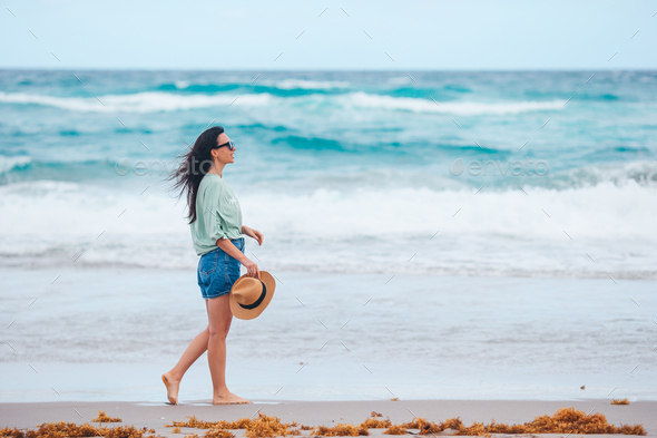 Young happy woman on the beach enjoys her summer vacation - Stock Photo - Images