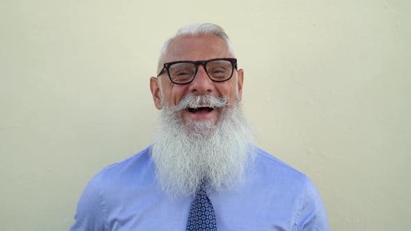 Happy trendy senior man having fun laughing in front camera - Fashion elderly male lifestyle concept alt