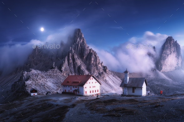 Mountains in fog with beautiful house and church at night