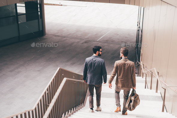 Two young businessmen outdoors walking downstairs - Stock Photo - Images
