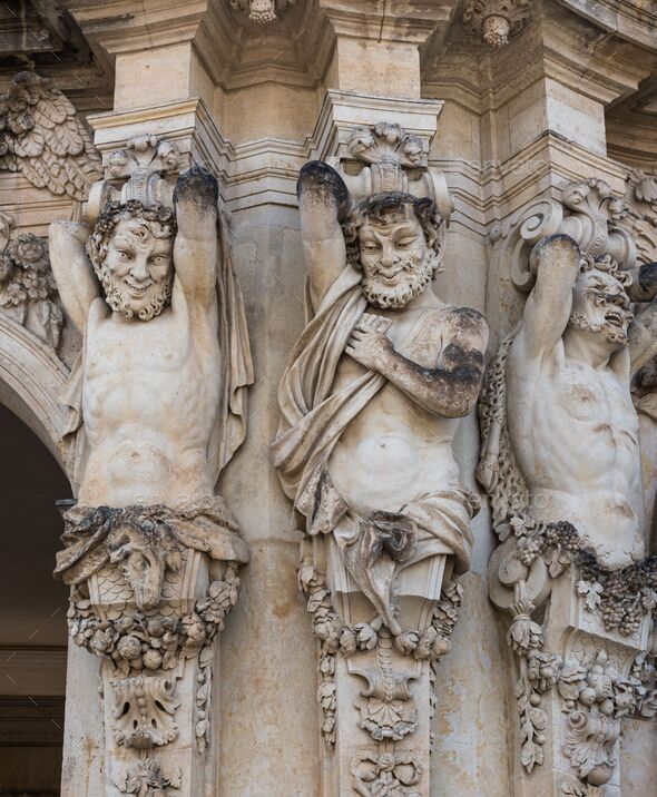 Three ancient statues of satyrs holding something Stock Photo by wirestock