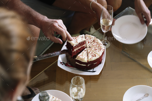 Person slicing and sharing his red velvet cake