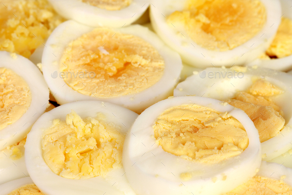 Closeup of multiple overboiled eggs cut in half and pilled upon each other