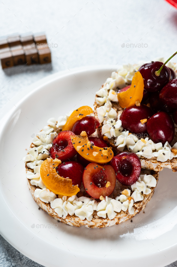 Rice cake with peanut butter and berries. Healthy dessert. Rice cake with cheese and fruits