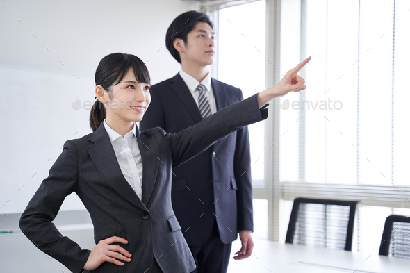 A Japanese businesswoman points to a goal in her office