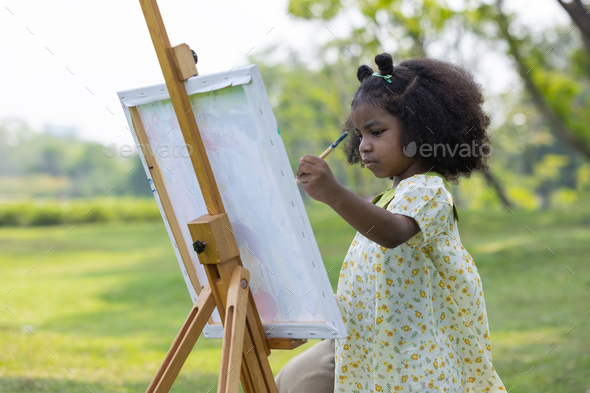Cute little girl painting at the park  - Stock Photo - Images