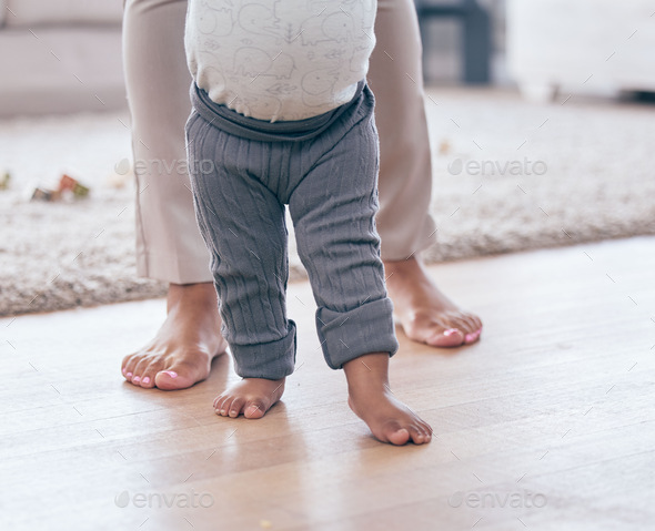 Baby feet, walking and learning with mother in a living room lounge with mobility development. Floo