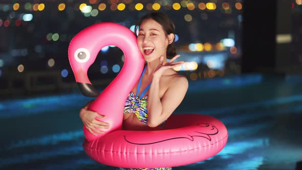 Asian young woman relaxing in swimming pool at luxury hotel spa alt