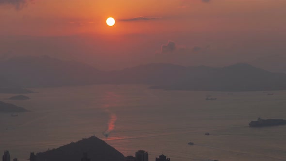 Timelapse Sun Sets Behind Hong Kong Harbor with Motorboats Pan Up alt