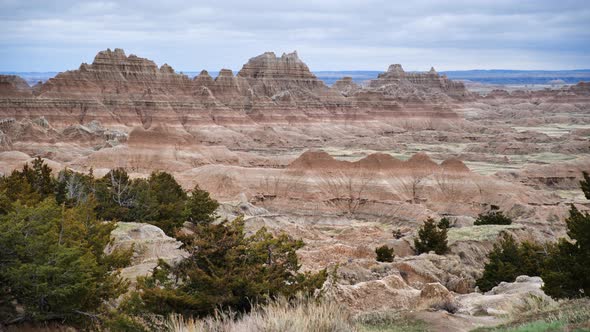 Rocky hills in South Dakota's Badlands, United States, with foliage blowing in the wind in the foreg alt
